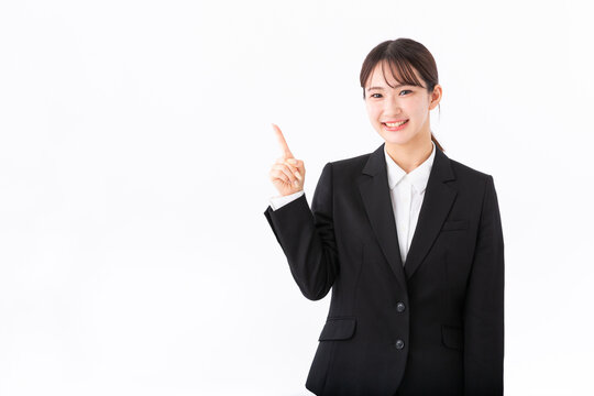 指をさす若いスーツの女性