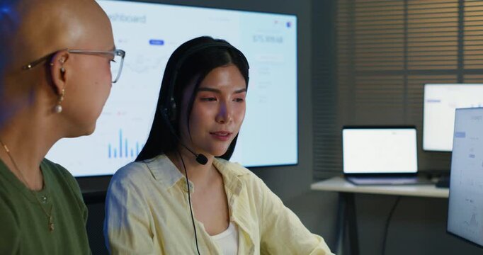 Two professional women planning sales strategies, discussing client needs and business solutions while using technology, teamwork, and communication in a modern corporate office.