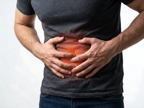 A man in a grey tshirt holding his stomach with both hands, showing signs of abdominal pain or discomfort, isolated on white background