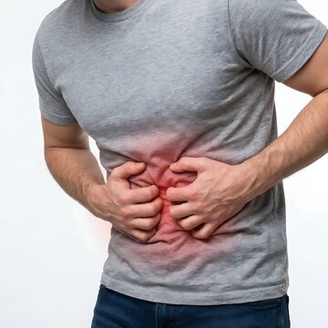 A man in a grey tshirt holding his stomach in pain, isolated on white background