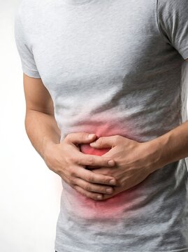 A man in a grey tshirt holding his stomach with both hands, experiencing severe abdominal pain or discomfort, isolated on white background