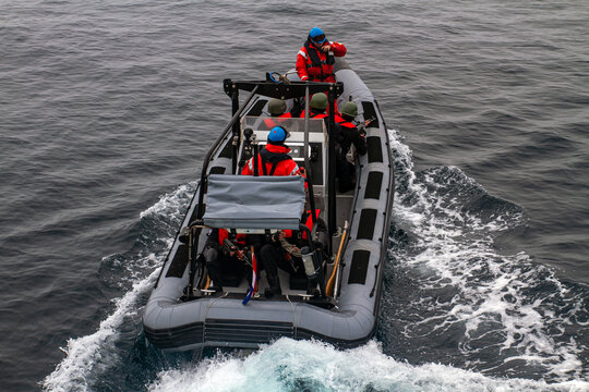 Navy SEAL team. Special Forces tactical mission. Rear view of a soldiars team on a speed boat.