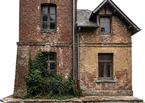 Architectural detail view of an old weathered brick building facade featuring multiple wooden windows vertical drainpipes a steep shingled roof and green ivy climbing up the masonry wall