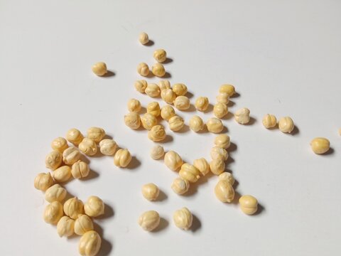 Dried Chickpeas Scattered on White Background with Natural Shadows
