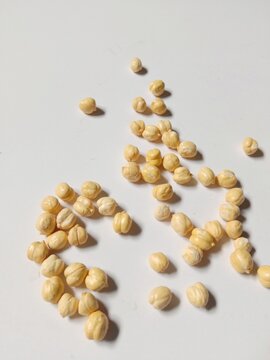 Dried Chickpeas Scattered on White Background with Natural Shadows