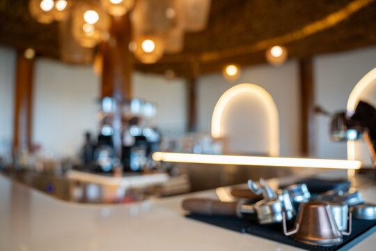 out of focus background of a cozy modern cafe with illuminated display case, coffee machine, and glowing neon arch lights. Creates a relaxing and upscale ambiance for design.