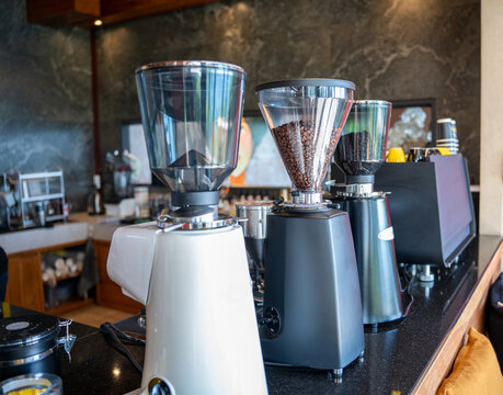 premium manual lever espresso maker positioned on a sleek dark counter in a modern specialty coffee shop, surrounded by professional barista brewing equipment and accessories.