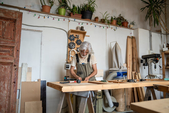 Hobby, profession and craftsmanship, professional man carpenter working in restoration workshop, handicraftsman renovating vintage wooden door at workbench in woodworking studio with instruments.