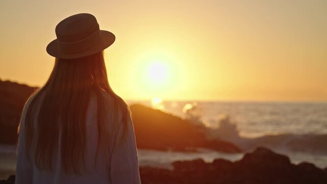 Woman in Straw Hat Watching Breaking Waves at Sunset