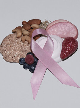 Pink awareness ribbon, healthy breakfast, and fresh fruit arranged as wellness concept