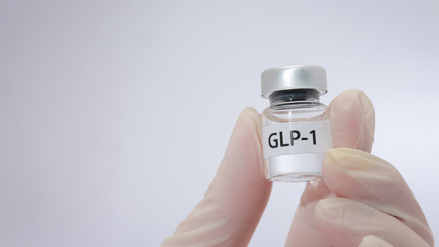Hand holds small glass vial for glp 1 injection bring hopeful mood for medical weight loss treatment on clear white background