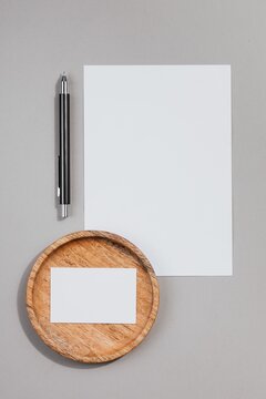 Blank Paper Sheet Mockup with Pen and Wooden Coaster Top View