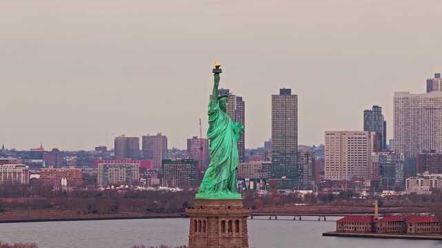 Liberty monument. New York City skyline. Liberty statue before New York City skyline. New York City landmark with Liberty monument. Liberty statue and New York City skyscrapers.