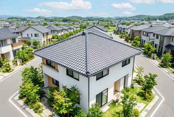 Fototapeta premium 寄棟屋根が特徴的な現代的な戸建て住宅と緑豊かな新興住宅街の街並み