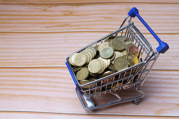 Shopping cart full of coins representing savings and wealth © JOSEANTONA