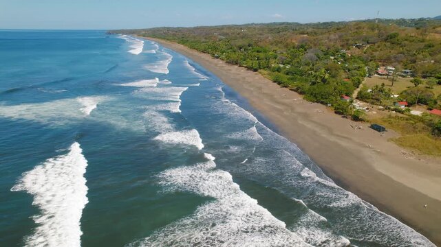Wide aerial view of Ostional beach with ocean waves rolling to shore Costa Rica
