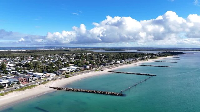 Wide aerial of Kurnell coastline with beaches and rock pier groynes, drone establishing orbit, Kurnell NSW Australia