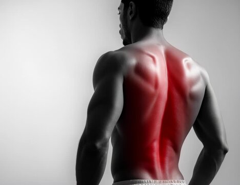 Athletic man with muscle injury holding his painful lower back, isolated on a white background