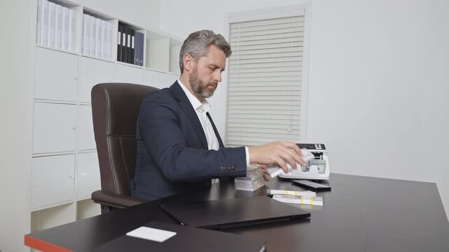 Businessman at office desk with money counting machine. Banker money counting in office. Financial control. Money operation in bank office. Business man in money counting process. Office worker.