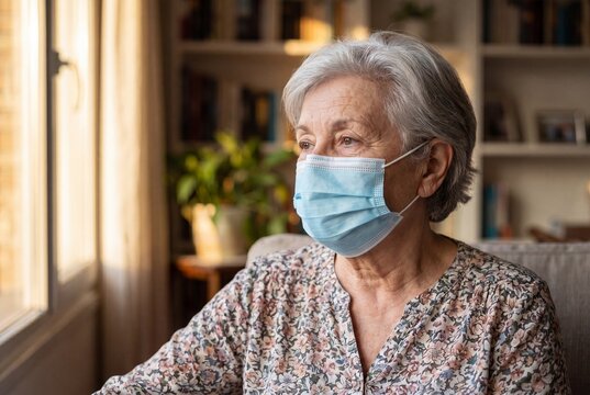 Portrait of a Senior Woman Wearing a Medical Face Mask at Home