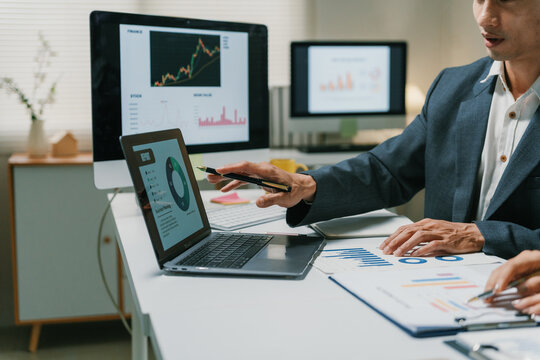 Business team collaborating on a project, analyzing market strategy, and reviewing company financial performance reports in an office