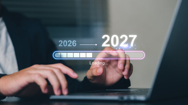 A professional using a laptop with a digital progress bar indicating the transition from the year 2026 to 2027, symbolizing progress and future planning.