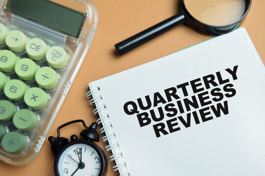 Concept of quarterly business review write on book isolated on table.