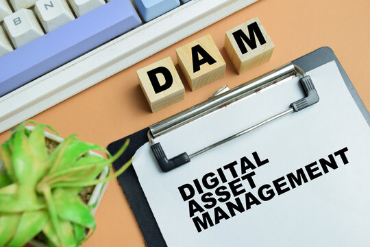 Concept of DAM - Digital Asset Management write on clipboard isolated on table.