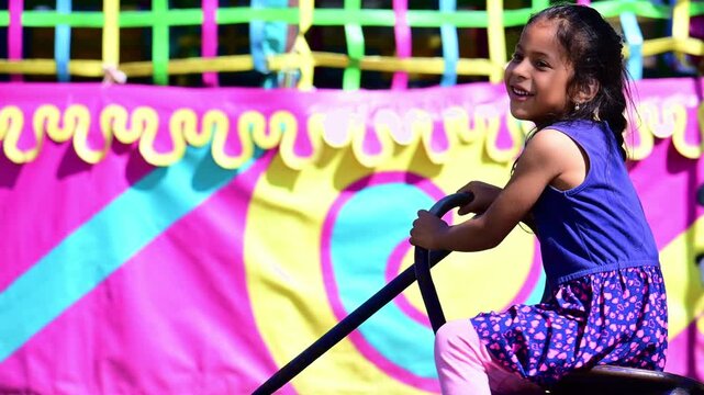 Latina girl playing on the seesaw at the park