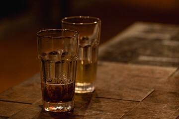 Fototapeta premium Two Drinking Glasses on a Warm Wooden Table