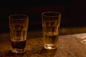 Naklejka premium Two Drinking Glasses on a Warm Wooden Table