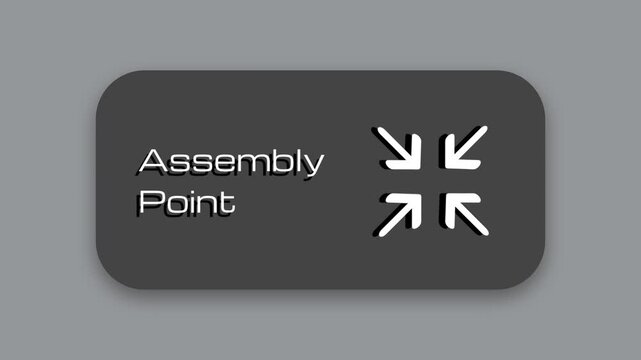 A dark gray wayfinding sign labeled Assembly Point featuring four small white arrows pointing inward together toward a central gathering point below