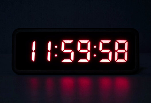 Bright red digital clock displaying the time as nearly twelve midnight in modern style