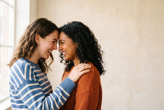 Two women sharing an affectionate kiss in warm natural light