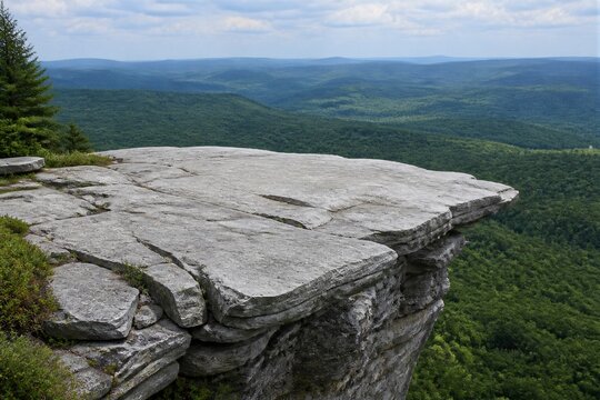 Rock cliff ledge overlooking forested valley panorama
