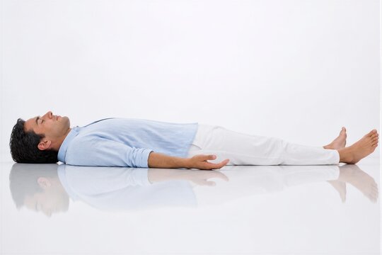 Man lying relaxed in supine position on reflective floor