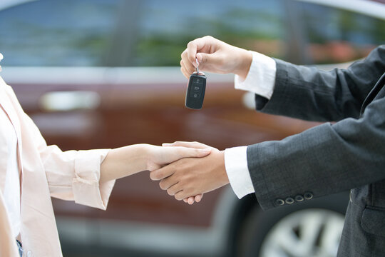 lease, rental car, sell, buy. Dealership manager send car keys to the new owner. Sales, loan credit financial, rent vehicle, insurance,  renting, Seller, dealer, installment, car care business