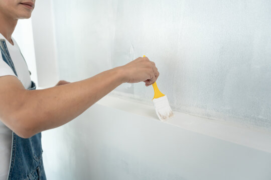 painter man, brush in hand for products to restore and paint the wall, indoor the building site of a house, wall during painting, renovation, painting, contractor, Architect, construction worker