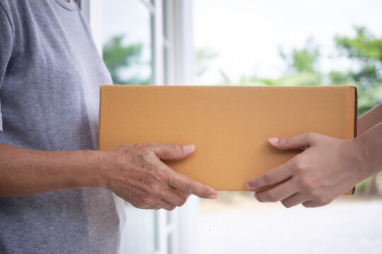 Happy smiling woman receives boxes parcel from courier in front house. Delivery man send deliver express. online shopping, paper containers, takeaway, postman, delivery service, packages