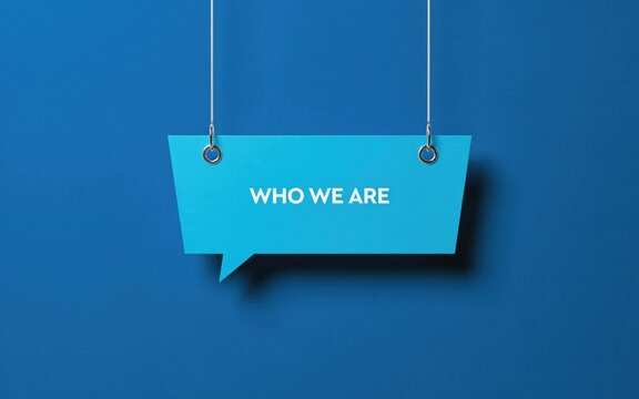 Bright blue hanging speech bubble sign featuring white who we are text displayed against a deep solid blue wall background
