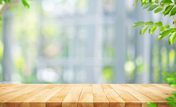 Selective focus.Real wood table top,counter top with blur big glass wall