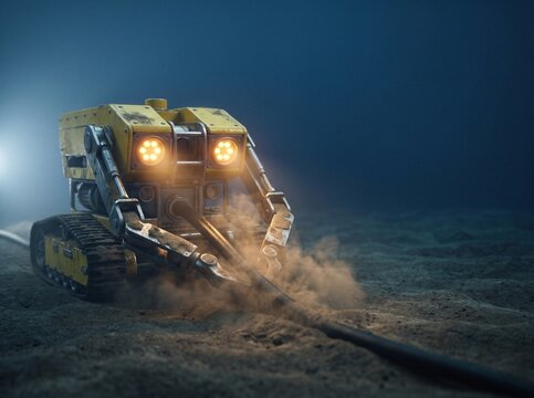 Yellow subsea crawler robot laying a fiber-optic communication cable on the deep ocean seabed, illuminated by glowing amber headlights
