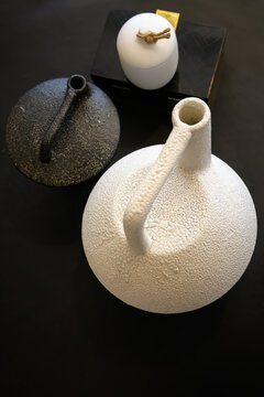 A top-down view showcasing textured pottery against a dark surface, highlighting a minimalist aesthetic in modern design in home decor setting - vertical