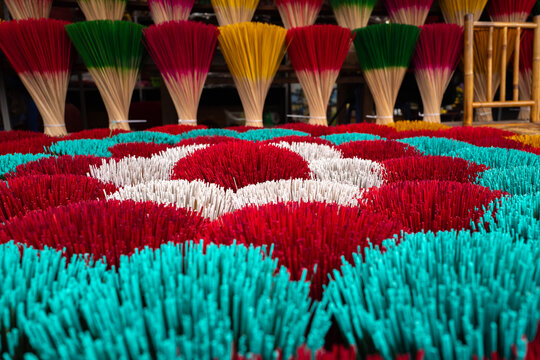 Vibrant incense sticks arranged artistically, captured in bright daylight, showcasing rich colors and intricate patterns - horizontal