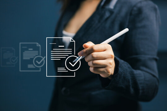 Business professional using stylus to approve virtual document with check mark, representing digital signature, document verification, online approval and electronic workflow process.