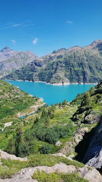 scenic mountain lake surrounded by alpine landscape and peaks under blue sky in Switzerland