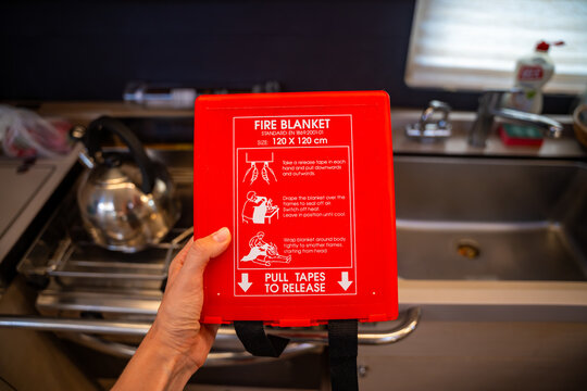Fire blanket mounted in a yacht galley for onboard emergency fire safety. Marine safety equipment for fire prevention and emergency preparedness at sea.