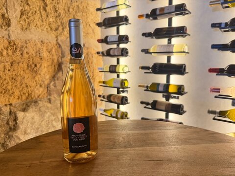 Palma, spain, august 2, 2026, pinot grigio delle venezie doc blush wine bottle standing on wooden table in a traditional wine cellar