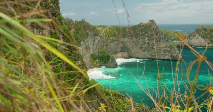 Steep cliffs drop into bright turquoise ocean at Diamond Beach viewpoint in Nusa Penida Bali Island