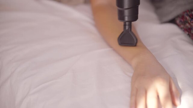 Hand Massaging Arm Muscle With Percussion Massage Gun Device